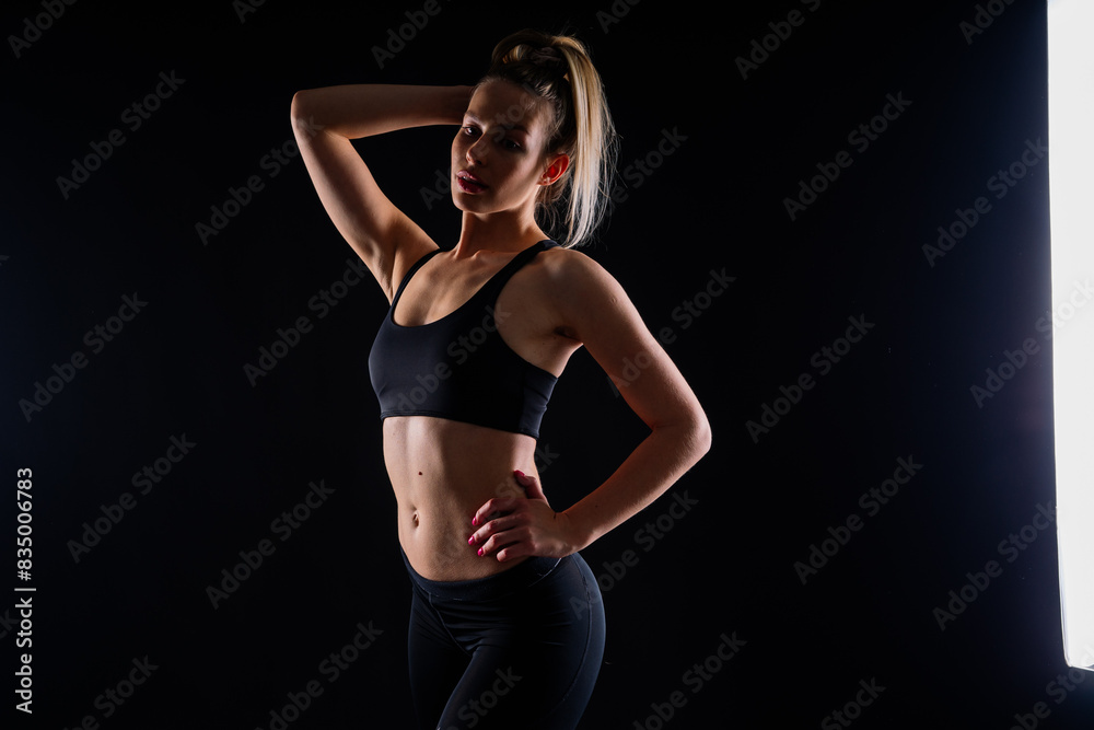 Obraz premium Fit sportswoman in leggings and sports bra looking away and while standing on yellow red