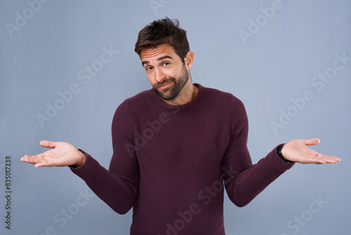 Smile, portrait and man in studio, question and confused with hands, why and asking with gesture. Blue background, mockup and fashion for person with cardigan, shrug and offer for sale of clothes