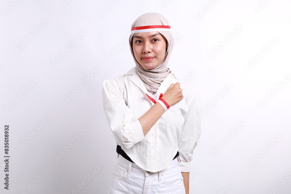 Young Indonesian muslim girl celebrate indonesia independence day with hand on the chest Young Indonesian muslim girl celebrate indonesia independence day with hand on the chest