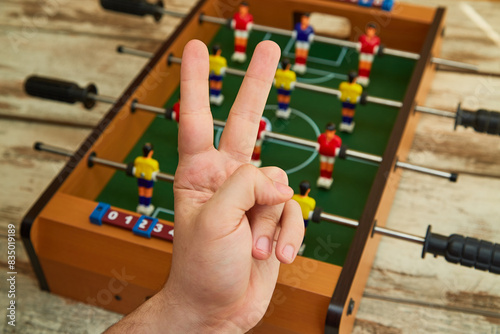 victory hand in the background of a table soccer game  winning a competition  sports table soccer game