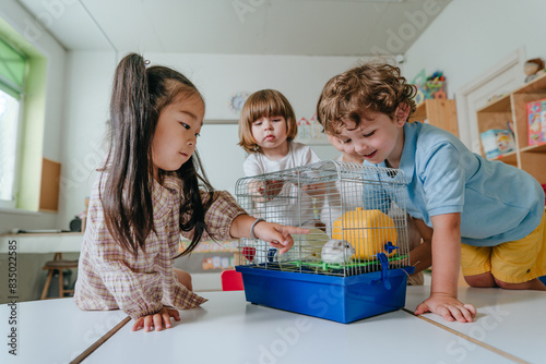 Children playing with hamster in kindergarten