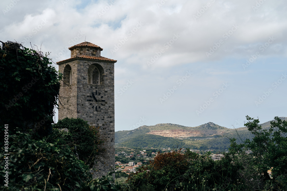 Obraz premium Clock tower within ruins of Old Bar medieval fortress. Montenegro country. A popular tourist destination to visit. Stari Bar - ruined medieval city on Adriatic coast, Unesco World Heritage Site
