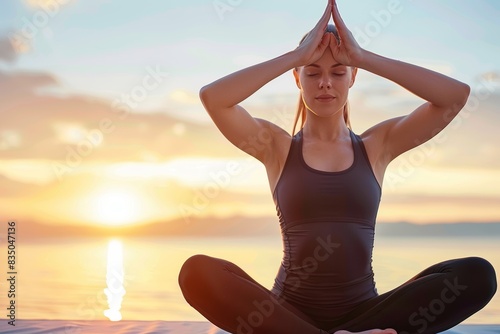 Serene young adult practicing yoga during sunset meditation by the lake