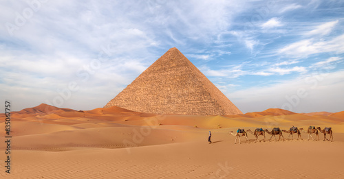 Camel caravan in front of the Great pyramid of Giza complex - Cairo, Egypt