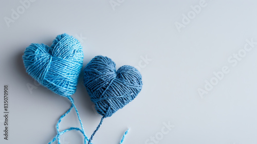 Two hearts made of threads on a gray background, close-up
