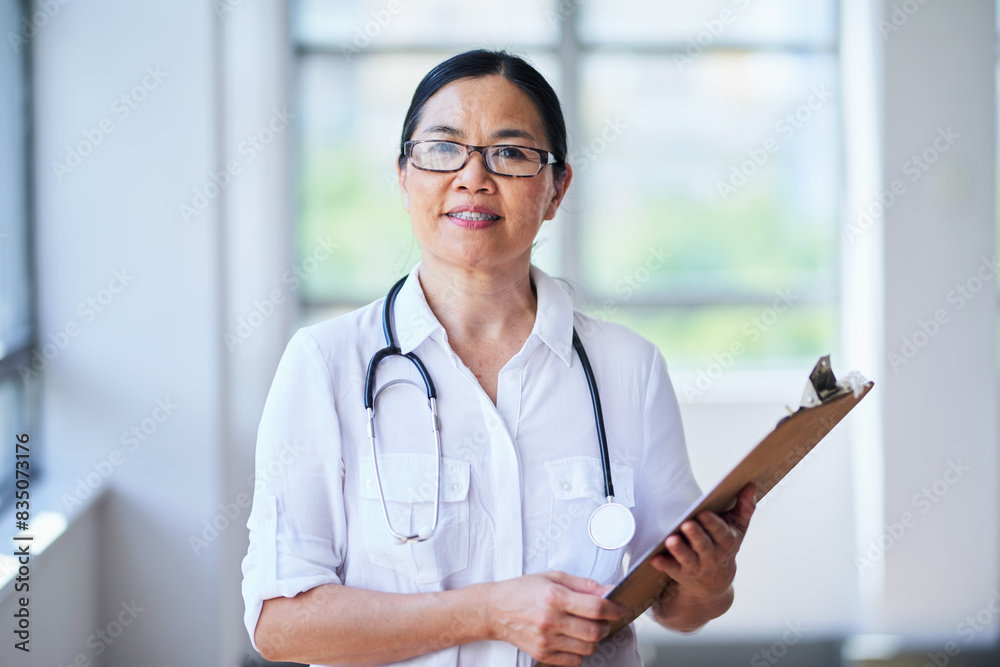 Confident Female Doctor Holding Clipboard in Hospital Corridor Confident Female Doctor Holding Clipboard in Hospital Corridor