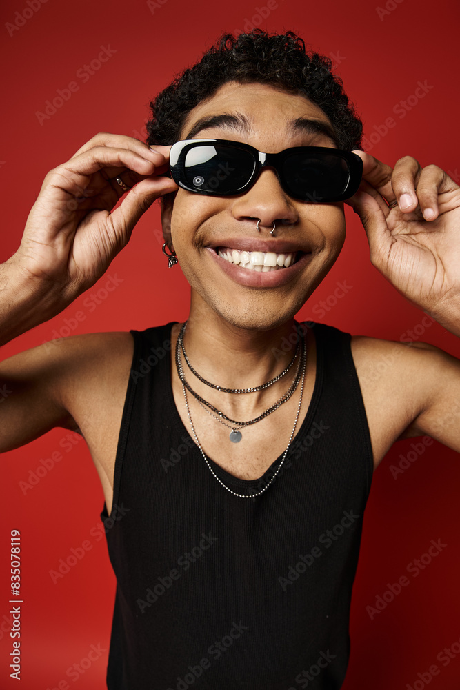 Handsome African American man smiling with sunglasses on red background. Handsome African American man smiling with sunglasses on red background.