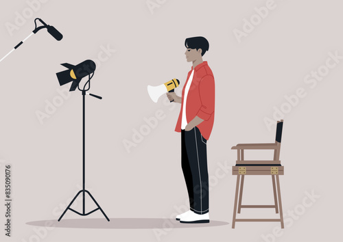 A movie director stands on a set, holding a megaphone, giving instructions, A spotlight and microphone are visible in the background