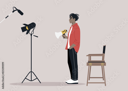 A movie director stands on a set, holding a megaphone, giving instructions, A spotlight and microphone are visible in the background