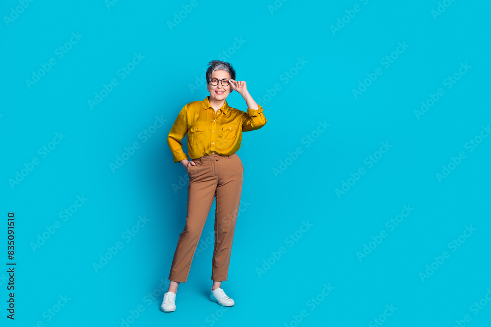 Full length photo of confident attractive lady dressed shirt glasses smiling emtpy space isolated blue color background Full length photo of confident attractive lady dressed shirt glasses smiling emtpy space isolated blue color background