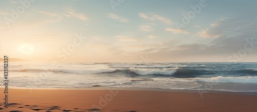 Surf gently meeting the sandy shore against the scenic horizon in a copy space image.