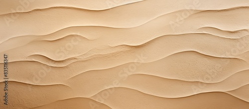 Background of a wavy light brown cement wall with abstract patterns and plenty of room for text or other elements in a copy space image. © vxnaghiyev