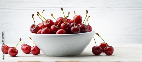 Cherries in a bowl on a whi...