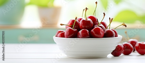 Cherries in a bowl on a whi...