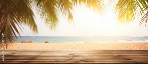 Summer beach party scene with blurred background and wooden table with leaves  ideal for copy space image.