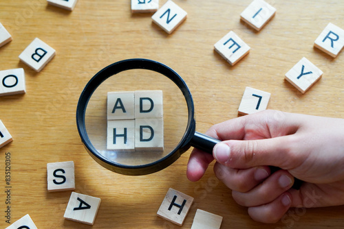 Foto magnifying glass with wooden letters ADHD attention deficit hyperactivity disord