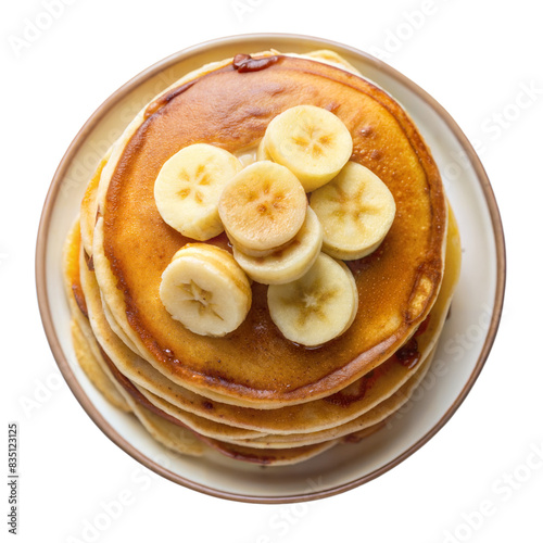 A close up image of a stack of golden brown pancakes topped with fresh banana slices