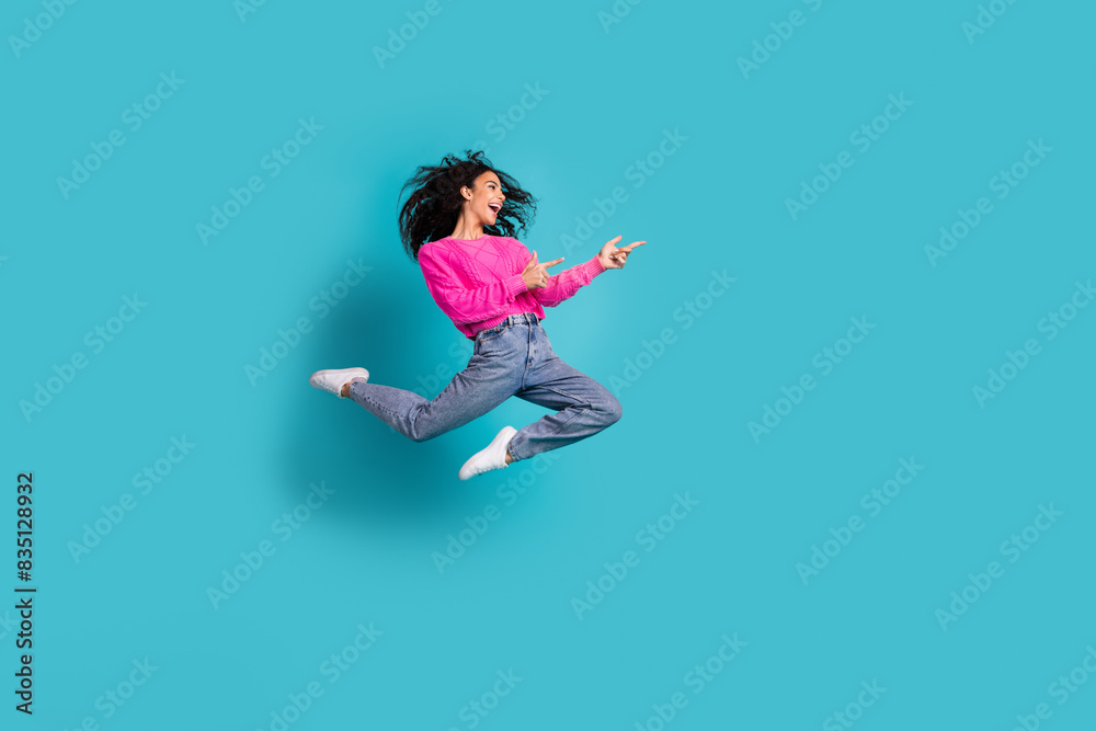 Full size photo of pretty teen girl jump point empty space wear trendy pink outfit isolated on aquamarine color background Full size photo of pretty teen girl jump point empty space wear trendy pink outfit isolated on aquamarine color background