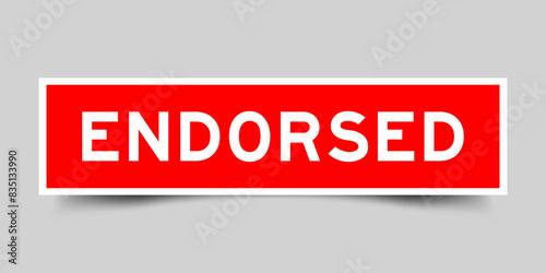 Red color square label sticker with word endorsed that inserted in gray background