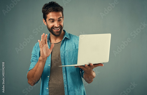 Happy, businessman and wave at laptop for video call or virtual meeting with communication isolated in studio. Smile, male perosn or employee with computer for networking, online interview or webinar photo