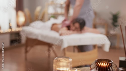 Charming Caucasian woman having massage with hot stones in spa center. Relaxed female client resting in wellness salon. Taking care about her body. Relaxation. Stone therapy concept.