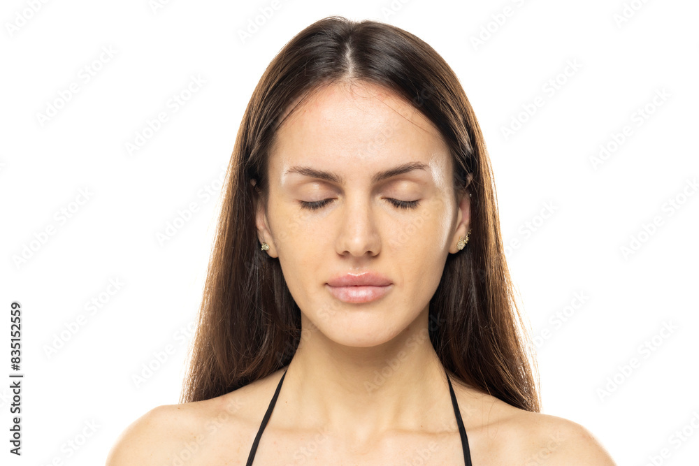 portrait of a young serious woman without makeup with closed .eyes on a white studio background portrait of a young serious woman without makeup with closed .eyes on a white studio background