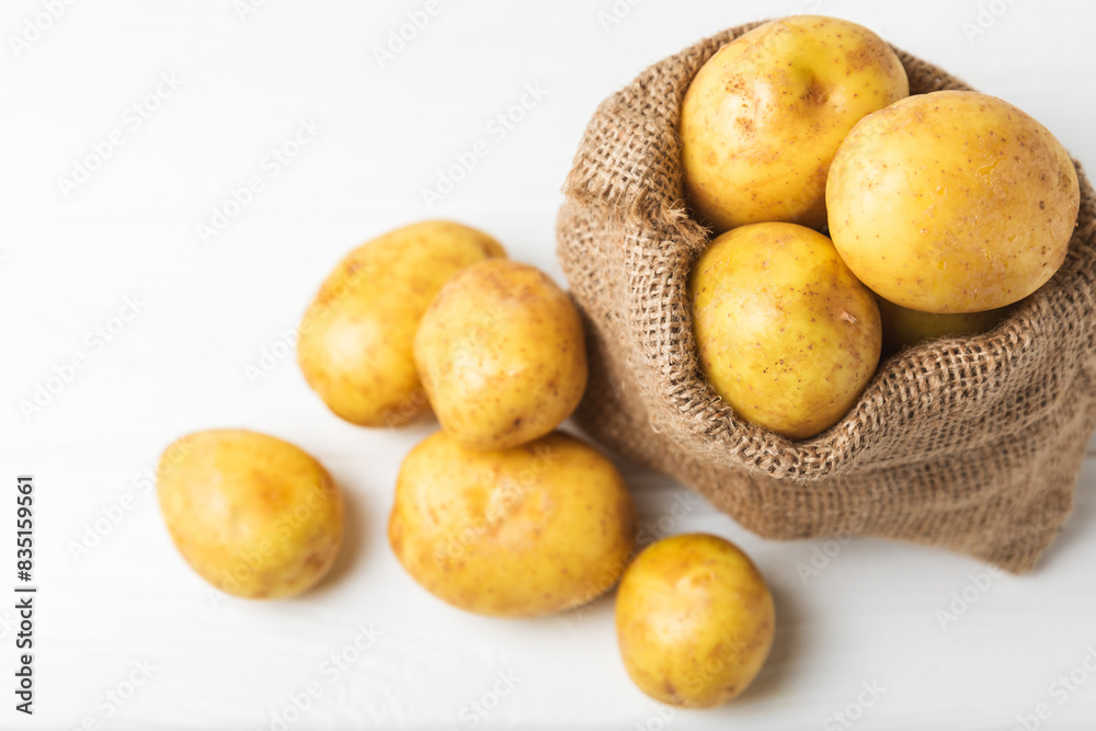 Young potatoes. Fresh potatoes on a wooden background. potato in burlap sack. Harvesting collection. organic, freshly dug potatoes. Agricultural background. Vegan. Vegetables.Place for text.Copy space Young potatoes. Fresh potatoes on a wooden background. potato in burlap sack. Harvesting collection. organic, freshly dug potatoes. Agricultural background. Vegan. Vegetables.Place for text.Copy space