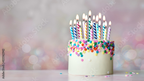 Colorful celebration birthday cake with colorful birthday candles and sugar sprinkles photo