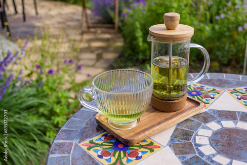 Serving tea with a teapot in a rustic bistro with a vium in flover's garden photo