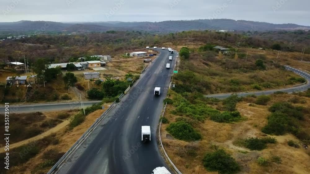 Panoramic erial shot of a highway in the middle of nowhere with a group of trucks of various sizes moving one after another 2.7K Panoramic erial shot of a highway in the middle of nowhere with a group of trucks of various sizes moving one after another 2.7K