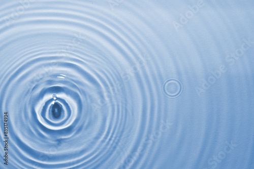 Rippled surface of clear water on light blue background, top view