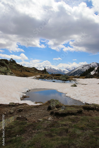 Pequeños lagos entre la nieve en un valle de alta montaña photo