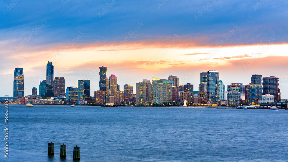 Naklejka premium Jersey City panorama at dusk as viewed from Pier 57, New York City, across the Hudson River