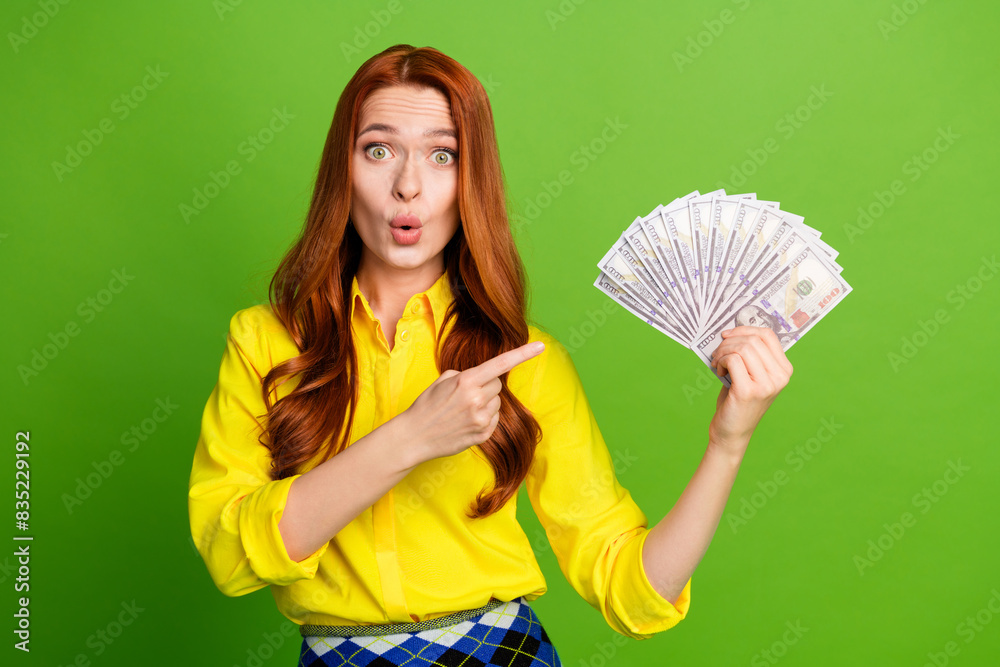 Photo of excited nice lovely wealthy woman wear yellow trendy clothes hold cash isolated on green color background Photo of excited nice lovely wealthy woman wear yellow trendy clothes hold cash isolated on green color background
