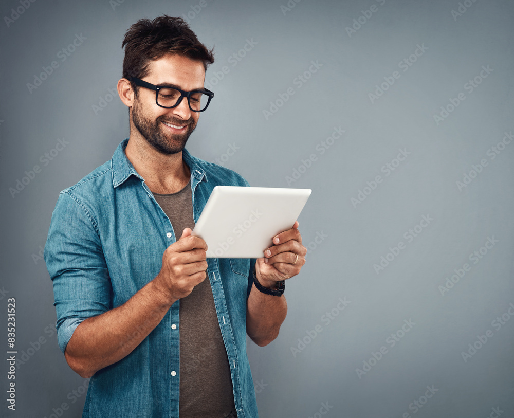 Man, studio and review with tablet and glasses, career with software programming in London. Male creative, ebook and gray background with happiness for digital job, mobile app or website development Man, studio and review with tablet and glasses, career with software programming in London. Male creative, ebook and gray background with happiness for digital job, mobile app or website development