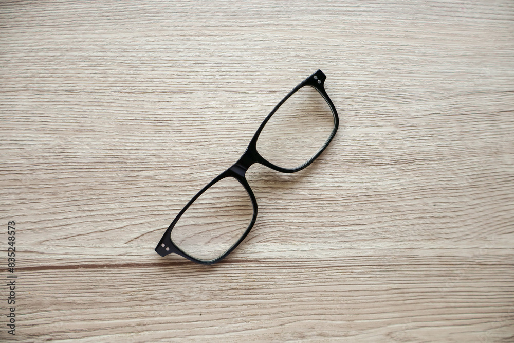 A pair of broken reading glasses without temples, placed on a table. The damage to the glasses is evident, showcasing the wear and tear from daily use A pair of broken reading glasses without temples, placed on a table. The damage to the glasses is evident, showcasing the wear and tear from daily use