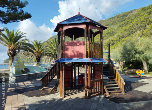 Riva Trigoso, Sestri Levante, Liguria, Italy, September 21, 2023: view of childrens playground in Riva Trigoso village with sea view, bench and palm trees at sunny day photo