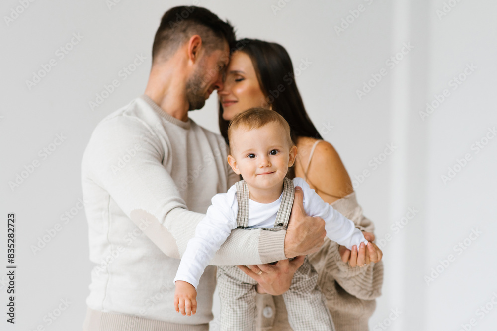 Happy young family with a young son in their arms on a white background Happy young family with a young son in their arms on a white background