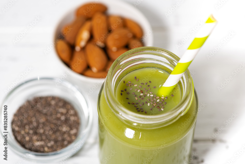 healthy superfood - green smoothie with chia seeds on white table healthy superfood - green smoothie with chia seeds on white table