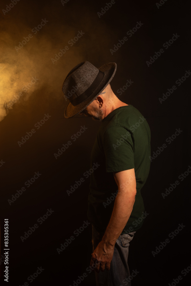 Mysterious man wearing hat standing posing for photo. Studio portrait. Mysterious man wearing hat standing posing for photo. Studio portrait.