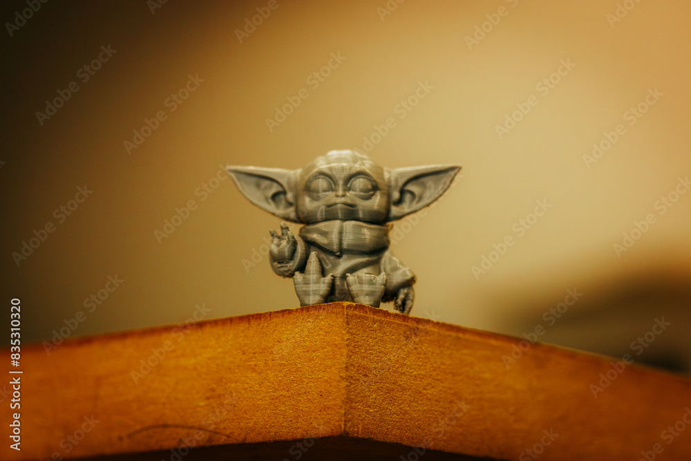 Fototapeta premium Madrid, Spain 7 May 2024 Din Grogu, Star wars toy hero made of recycling plastic isolated on yellow background. Happy baby Yoda from Disney series.