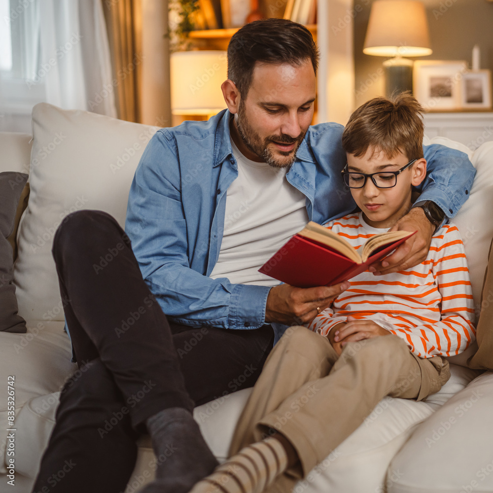 Father and son read a book and have fun while spend time together