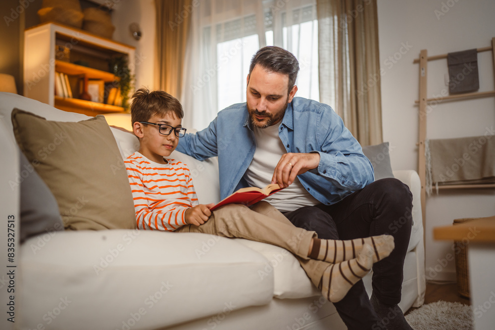 Obraz premium Father and son read a book and have fun while spend time together
