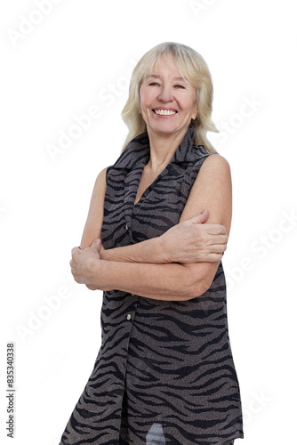 A smiling elderly woman in a stylish suit stands with her arms crossed over her chest. Happy age, health and positivity. Isolated on a white background. Vertical.