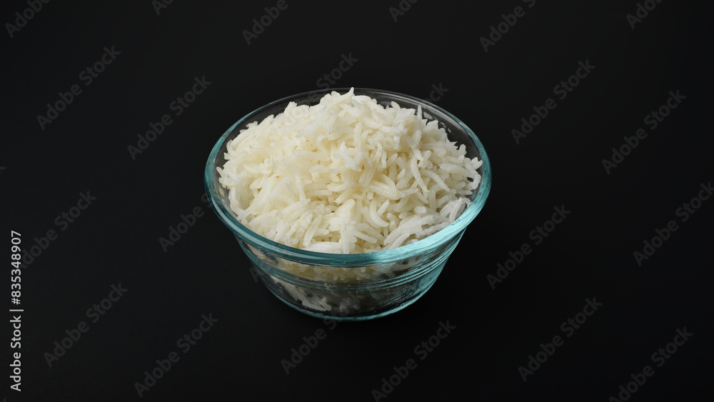 a small serving of basmati rice in a glass bowl on a black background a small serving of basmati rice in a glass bowl on a black background