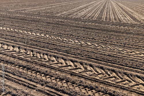 a plowed agricultural field with traces of a tractor