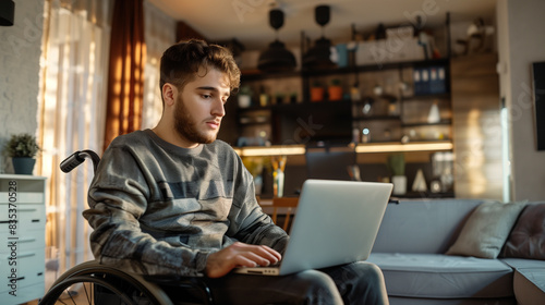 Man in a wheelchair in a modern home office working with a laptop