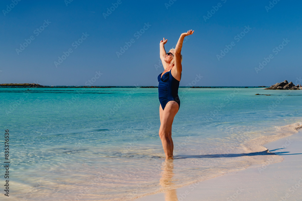 Happy senior woman enjoying the sea and sun on the beach Happy senior woman enjoying the sea and sun on the beach