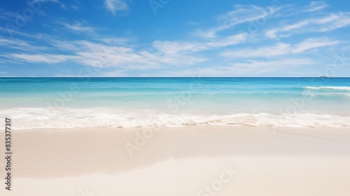 A picturesque beach scene with clear blue sky, tranquil ocean, and golden sand
