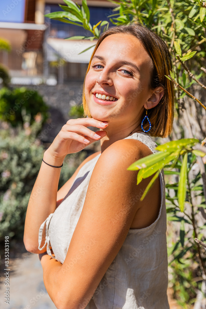 A young redhead woman is smiling and posing for a picture, vertical shot A young redhead woman is smiling and posing for a picture, vertical shot